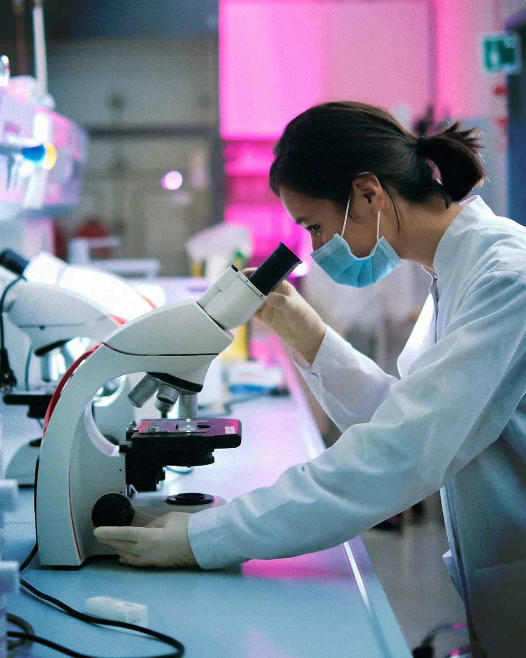 woman looking into microscope