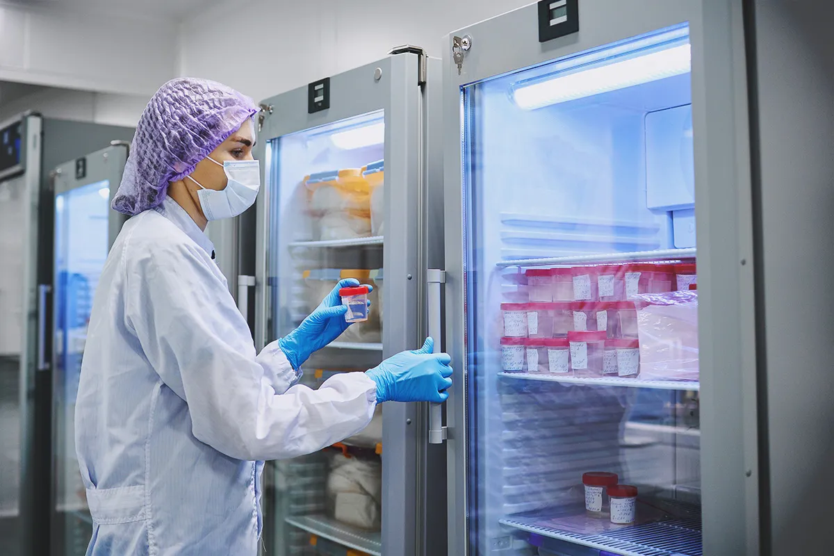 woman looking into contained specimens