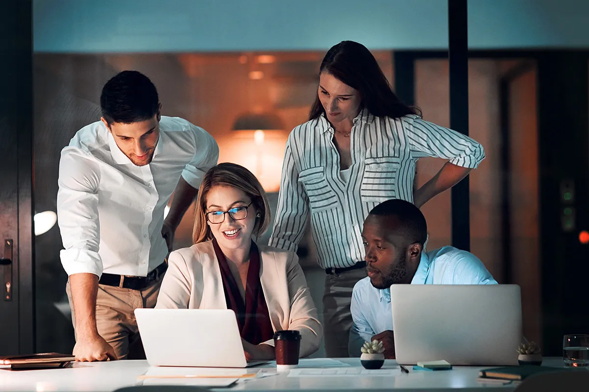 colleagues gathered around a laptop