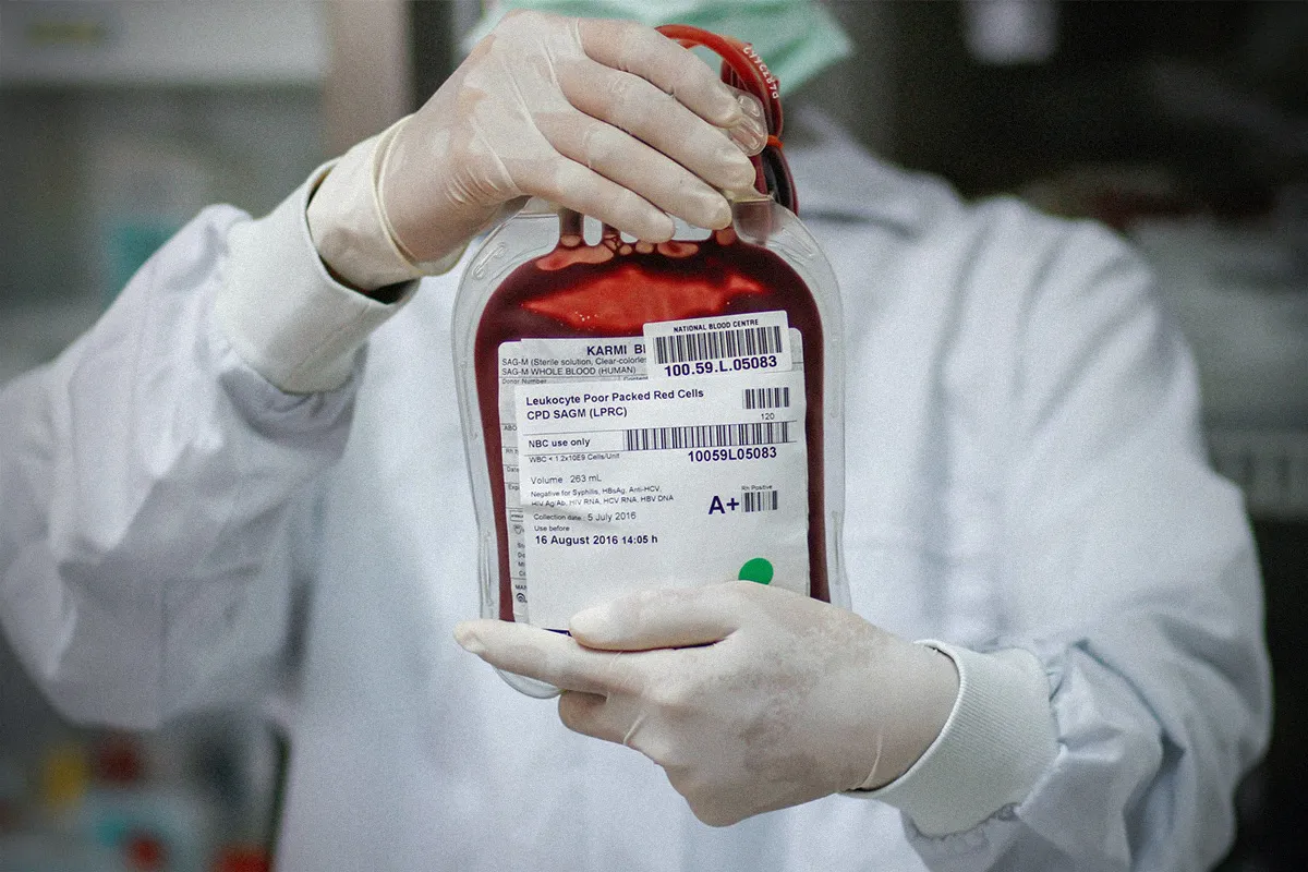 person holding transfusion bag